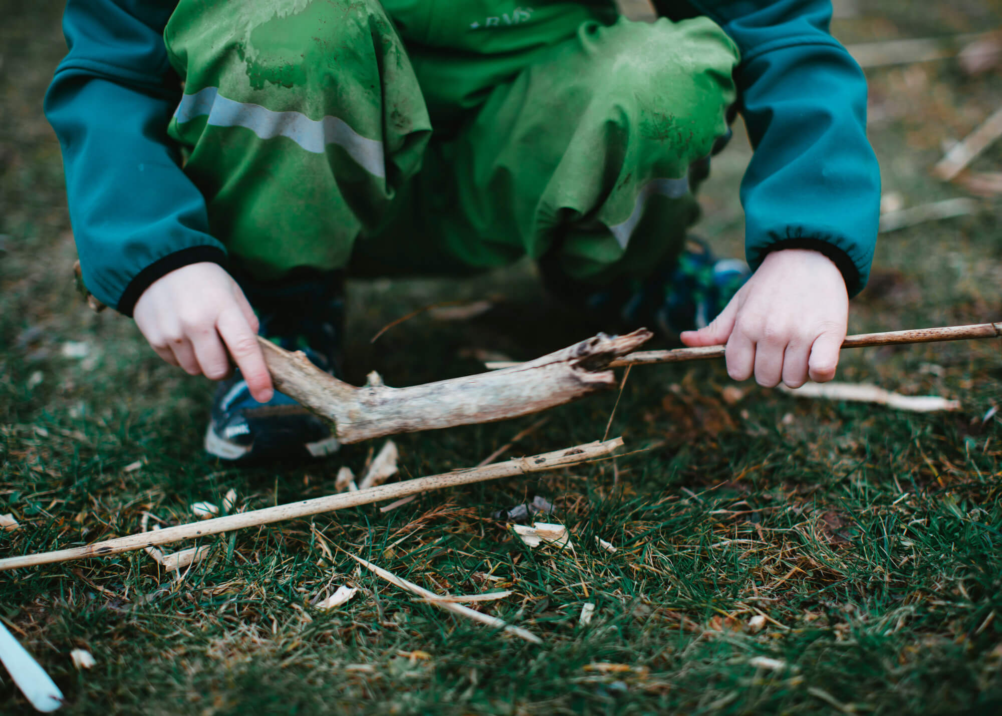 Little boy picking up sticks